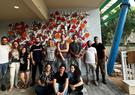 Leidos Israel team posing for a group picture in front of a wall painted with flowers.