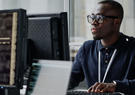 man working on computer with monitor displaying code