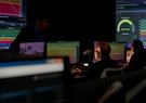 A man sitting in front of multiple screens