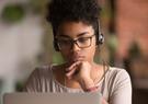 A teenager wearing headphones while taking an online course