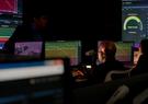 A man sitting in front of multiple screens