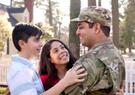 A military family holding each other
