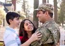 A military family holding each other