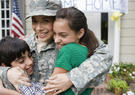Soldier mother embracing children