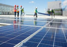 solar panels with utility workers in background