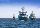 Three ships travel across the ocean.