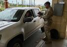 A soldier scans another soldier's credentials. 