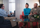 A service member and spouse sit in a room with a social worker.