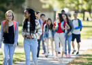 A multi-ethnic group of high school age students are walking to class together before school.