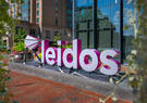 The Leidos sign is viewed in between spring flowers.