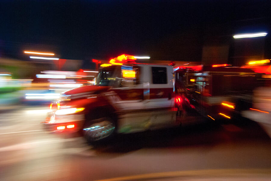 Stylized motion-blurred image of a fire truck en route.