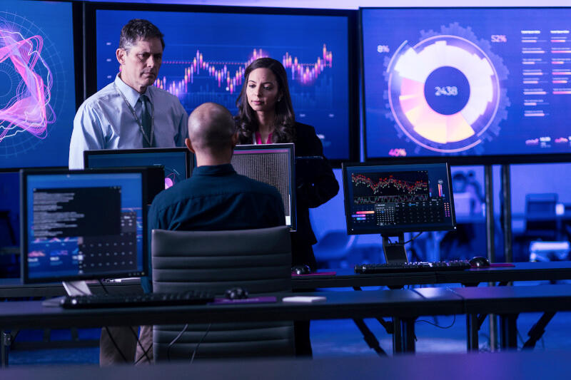 team working with large monitors behind them