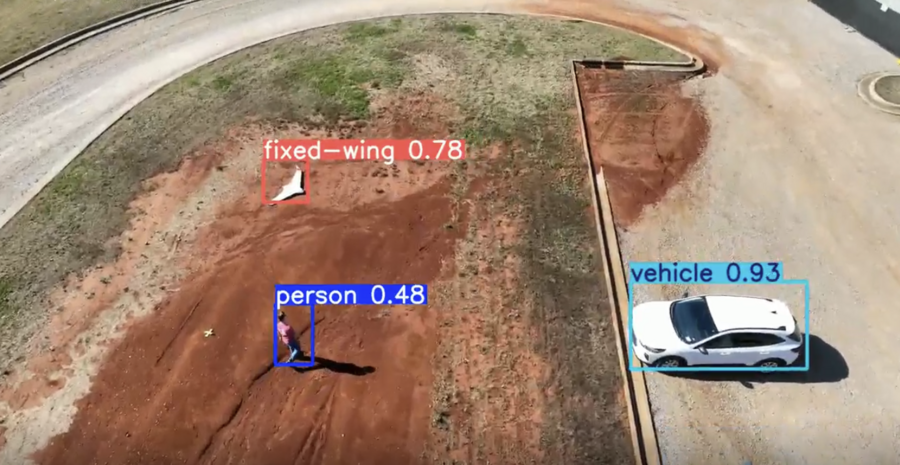 image of a field test where a person, a fixed image and vehicle are identified using our Leidos technology in different colored squares