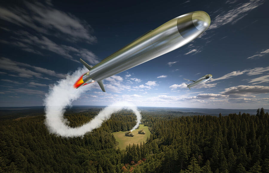 A silver missile flying through the sky with a trail of exhaust smoke leading to a launcher in a small clearing in a wooded area.