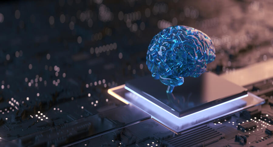 A translucent blue brain model sits atop a glowing computer chip on a circuit board, symbolizing artificial intelligence, machine learning and advanced computing technologies.