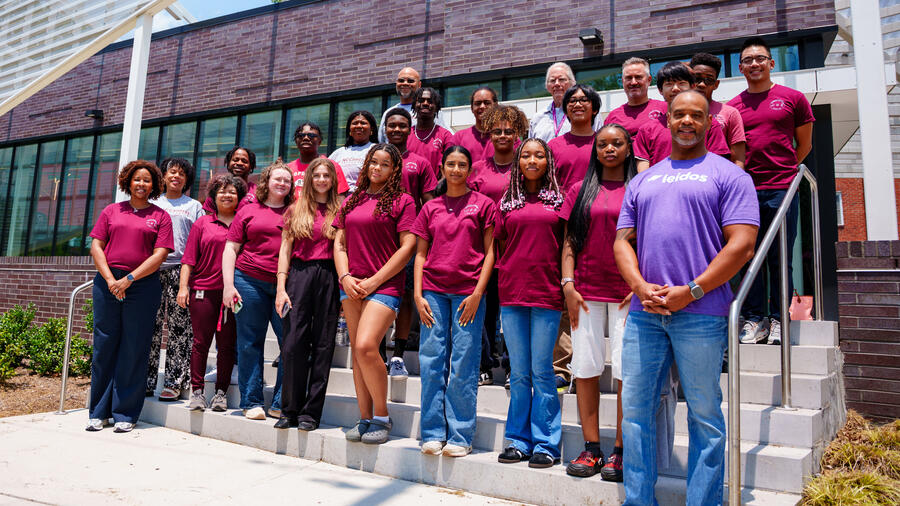 Group of high school students, educators, and Leidos representatives pose outside North Carolina Central University during a STEM program focused on artificial intelligence and emerging technologies.