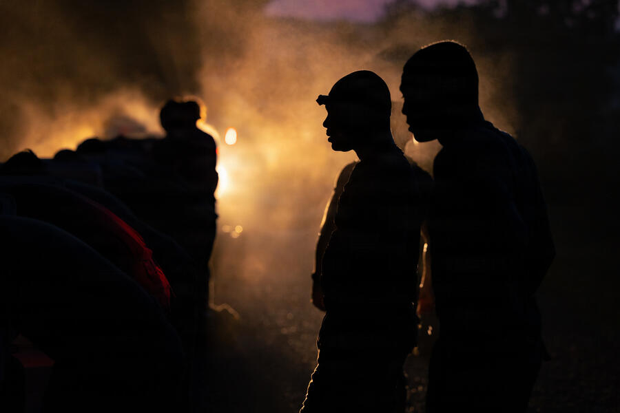 Dark image with silhouettes of US Army ROTC cadets with the backlight obscured by fog