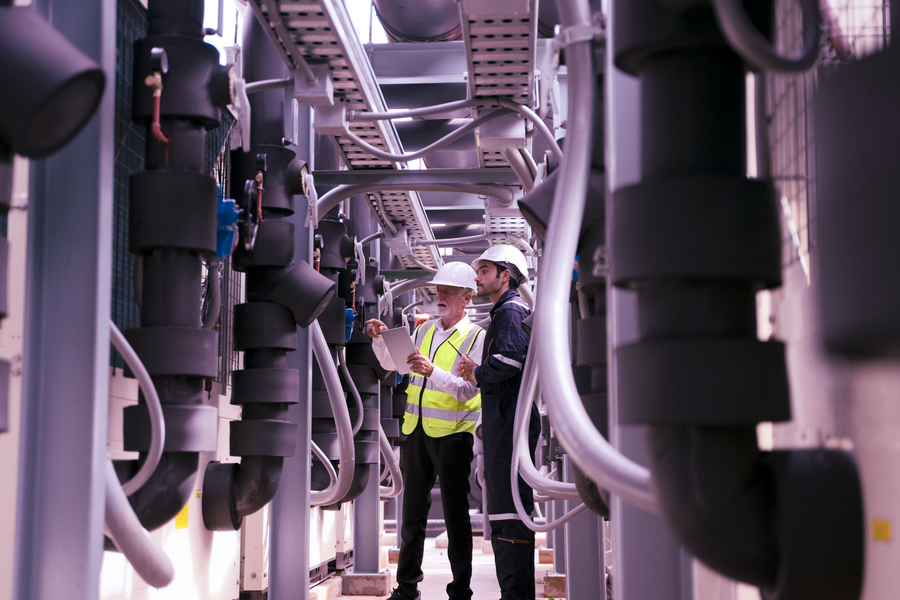 Two engineers working on industrial system on roof