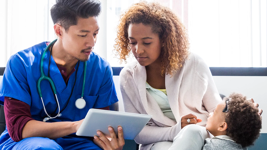 A doctor consulting with patients using a tablet device