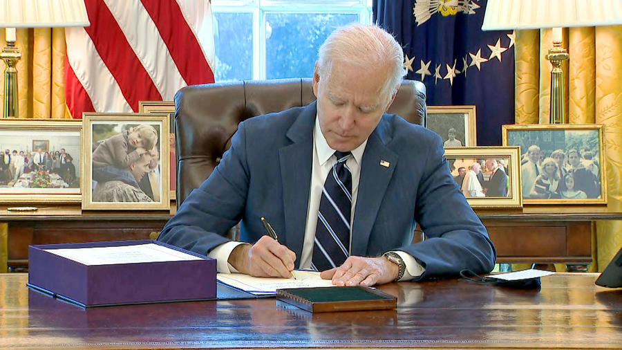 President Joe Biden signing bill in Oval Office