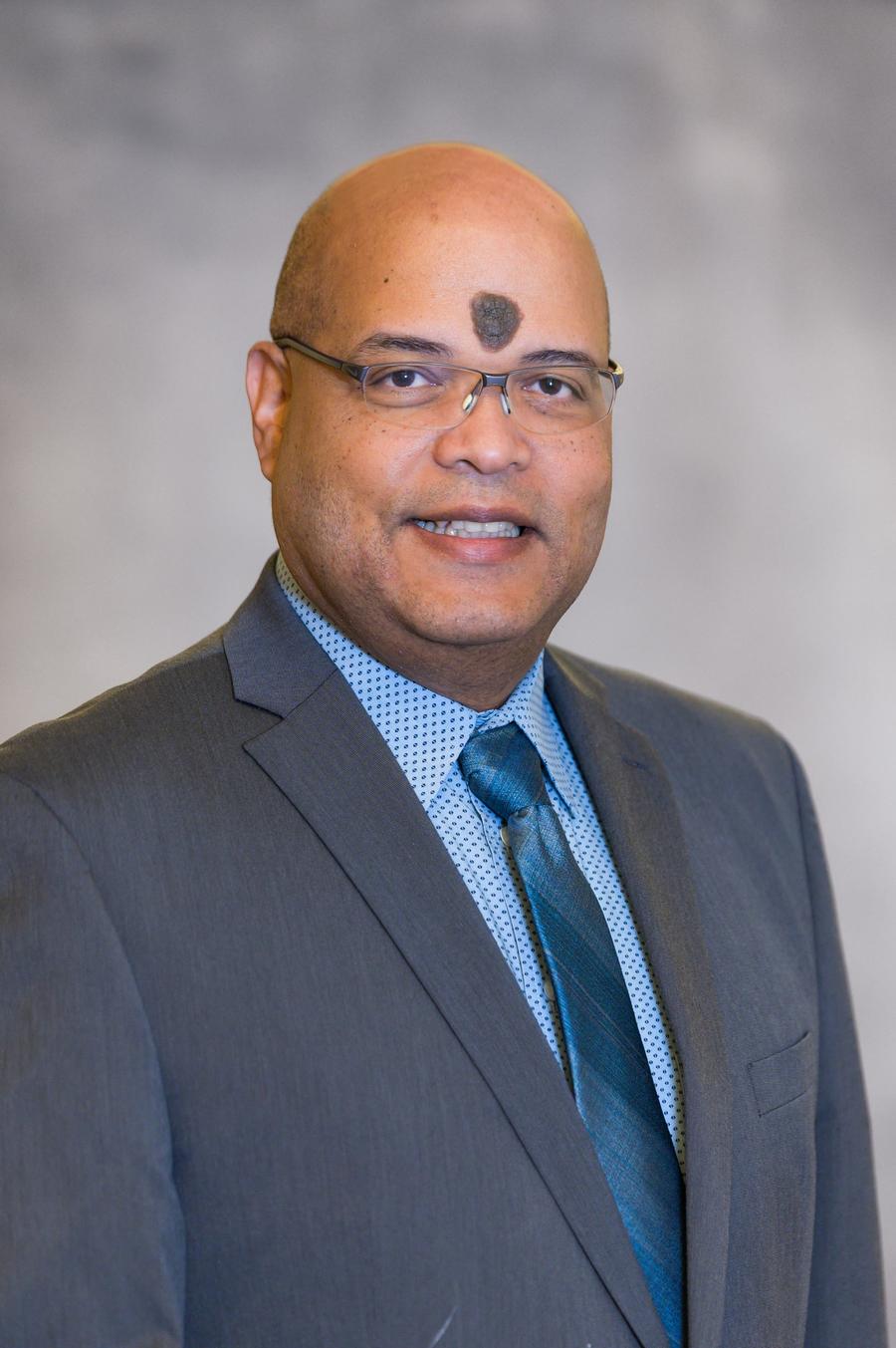 Dr. Braulio Cabral headshot on a gray background