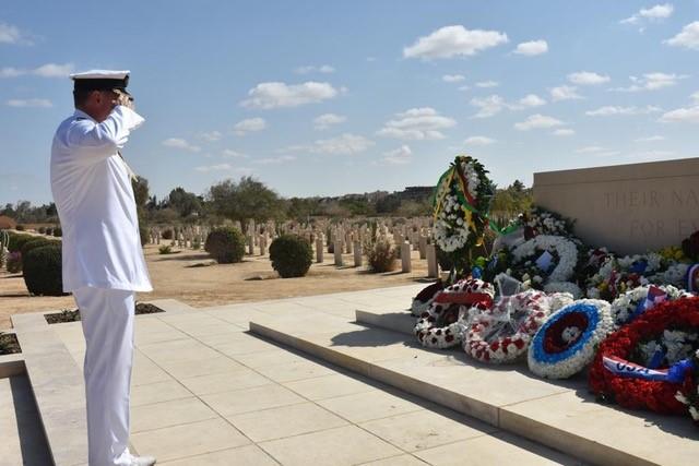military officer saluting memorial