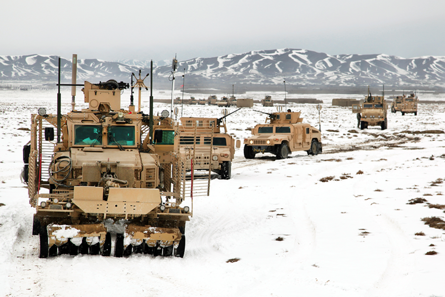 Humvees in a caravan driving through snow