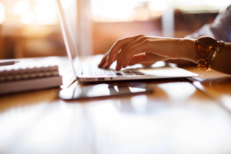 Woman typing on laptop at a cafe