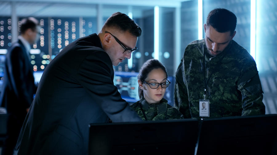 Military and intelligence personnel looking at computer