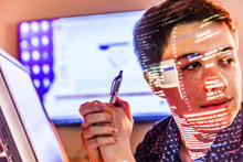 employee holding a Leidos pen