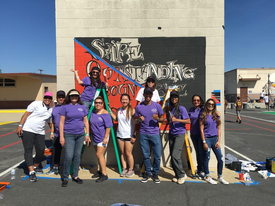 A group standing in front of a mural