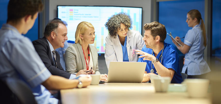 photo showing team of doctors, nurses and administrators discussing care