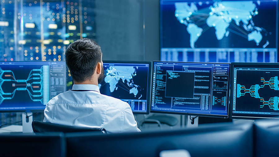 control room with screens images of maps