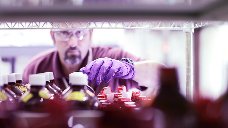 Man with goggles counting medication bottles