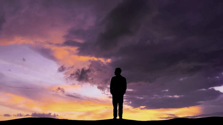 Silhouette of person with sunset behind them