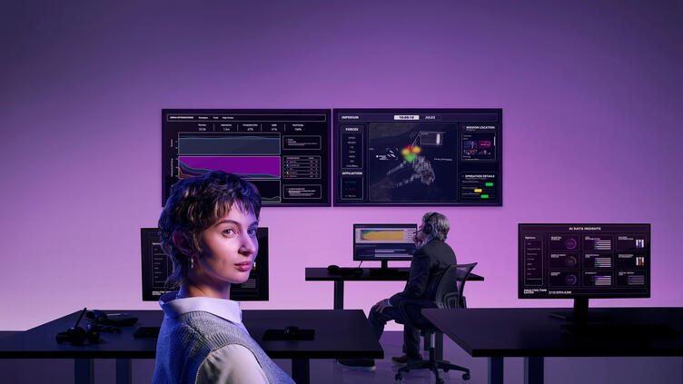 woman in front of large computer bays displaying data