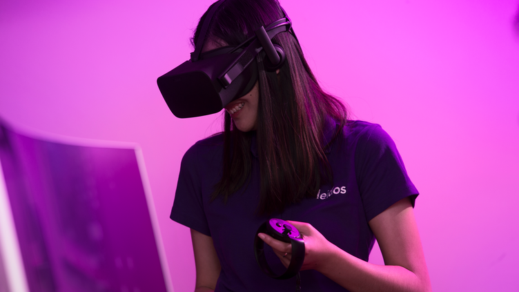 A woman in a VR headset wearing a Leidos shirt