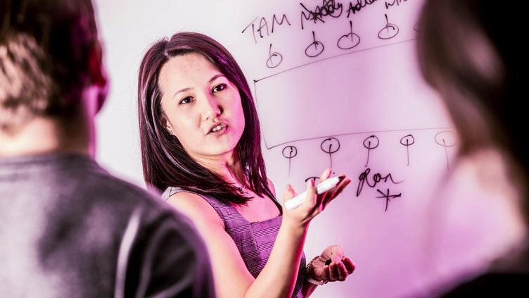 A woman drawing on a whiteboard