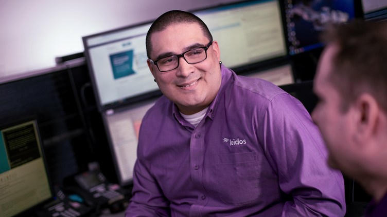 A man in a purple shirt smiling