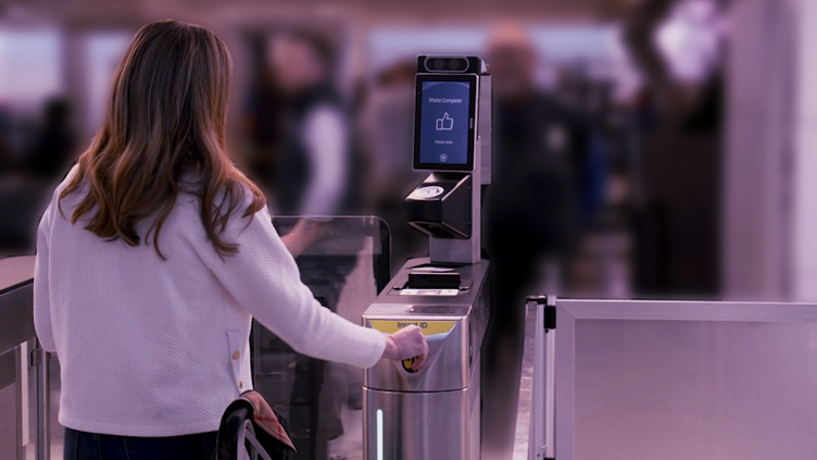 Woman using electronic gate at airport checkpoint