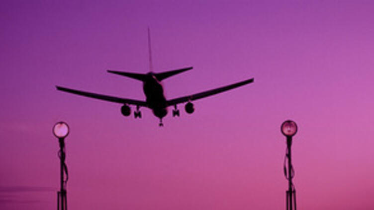Plane landing with purple sunset