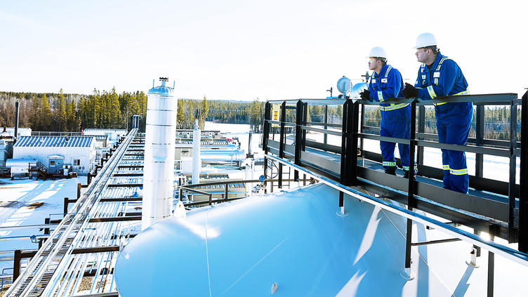 Worker looking over a plant from an elevated walkway