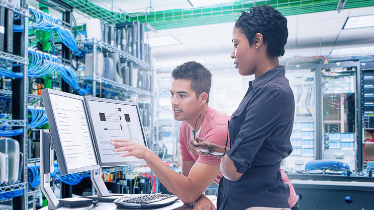 coworkers discussing and pointing at a monitor