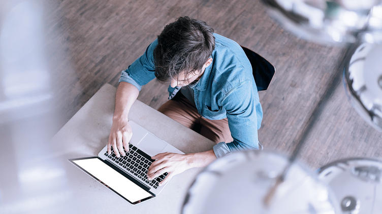 Man sitting at desk on laptop from bird's eye view