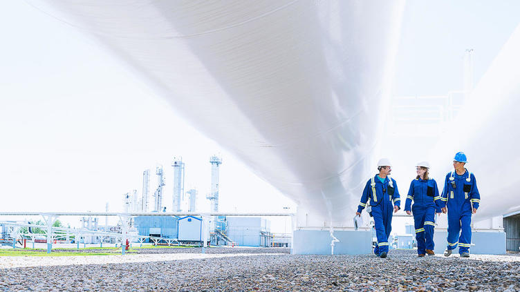 Three coworkers walking together at a power plant