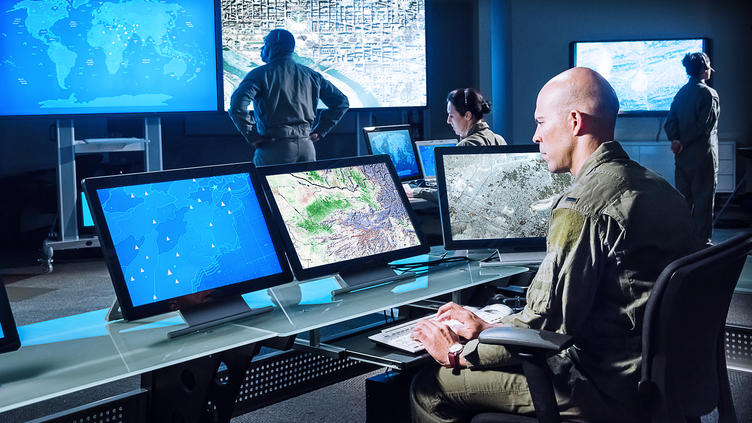 Man looking at computer screen in a command center