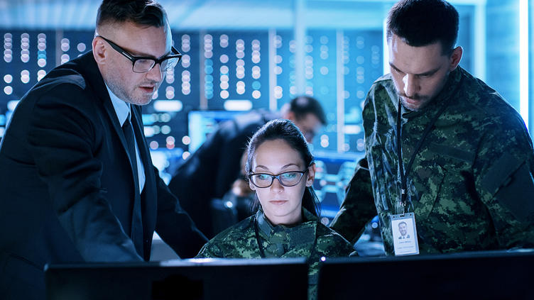 three coworkers looking at monitor together