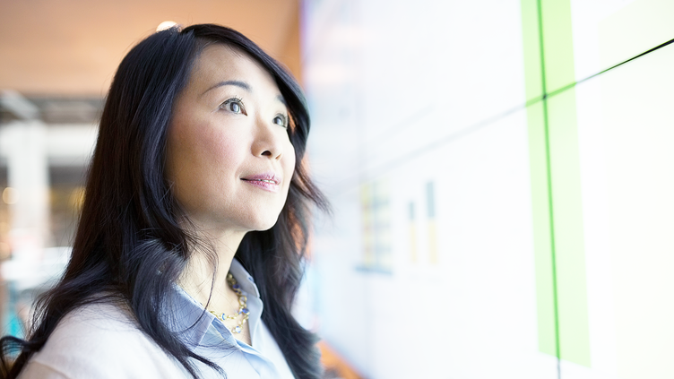 woman looking up while reviewing monitor screens