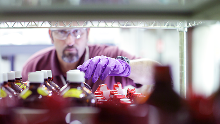 man with goggles and gloves checking inventory on shelf