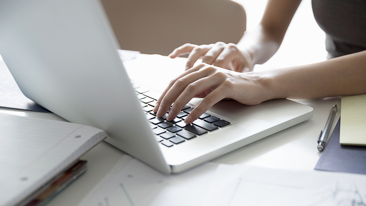 hands typing on laptop keyboard